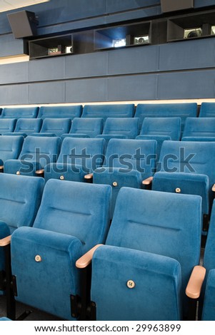 Close-up of empty cinema auditorium with line of blue chairs.