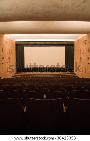 Empty cinema auditorium with line of chairs and projection screen. Ready for adding your own picture.
