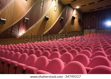 Empty cinema auditorium with light beam from projector.