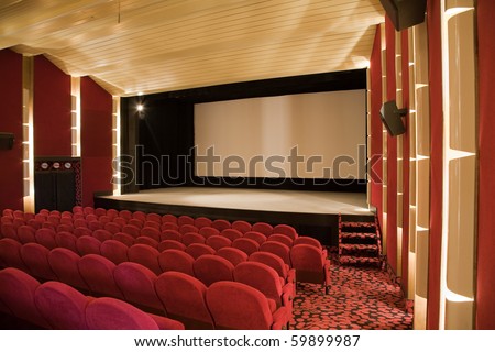 Empty cinema auditorium with line of chairs and projection screen. Ready for adding your own picture. Side view.