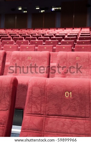 Close up of cinema auditorium interior with lines of chairs.