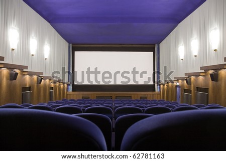 Empty cinema auditorium with line of chairs and projection screen. Ready for adding your own picture. Front view.