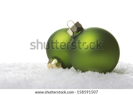 green christmas balls on artificial snow with white background