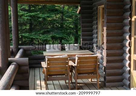 A small desk and chairs outside on the cabin balcony.