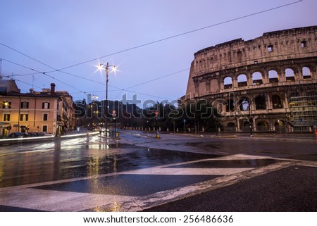 Famous Colosseum and car trails by the road passing by it. Taken at sunrise.