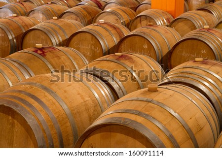 Selected wine varieties go through the aging process in oak wine barrels  in a winery cellar on Crete.