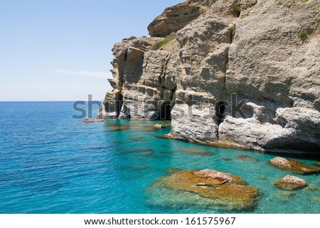 Soft steep pebble rock cliffs towering over the turquoise waters at the south coast of Crete.