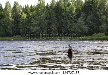 Fisherman catches in swedish salmon river
