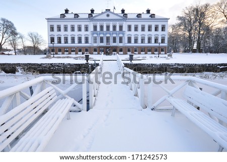 Mansion stand by the frozen river in winter at sunrise