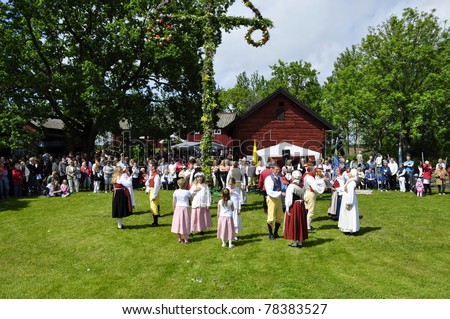 TORSTUNA, SWEDEN-JUNE 19: Folklore ensemble of Sweden in traditional folk costume perform a harvest dance around the midsummer tree at Midsummer Day on June 19, 2009 in Torstuna, Sweden.