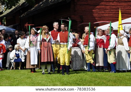 TORSTUNA, SWEDEN-JUNE 19: Folklore ensemble of Sweden in traditional folk costume perform a harvest dance around the midsummer tree at Midsummer Day on June 19, 2009 in Torstuna, Sweden.