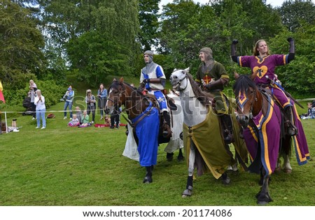VITTINGE, SWEDEN - JUNE 26: Unidentified people in in knight armor on the horse during tournament reconstruction near Vittinge old church on June 26, 2014 in Vittinge, Sweden