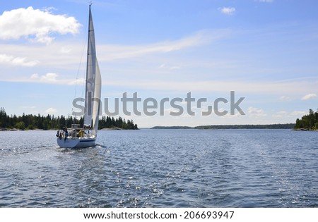The sailboat is moving along the coast in Sweden