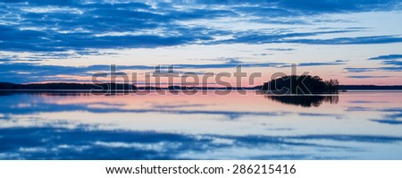 Calm lake reflection at midnight light in Sweden