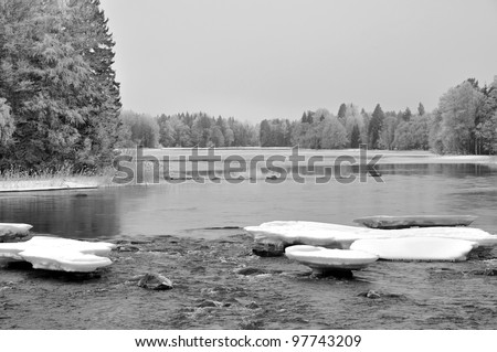 Black and white picture of frosty river landscape