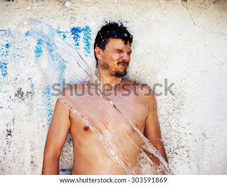 Man Gets Water Splashed in Summer in Summer on Grunge Background