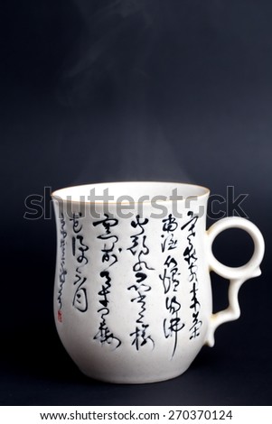 Chinese teacup in black Translation In a cold night a guest is coming,us the tea instead of wine, the fire is just light up,the moon in front of window like usual, different because of blossom flowers