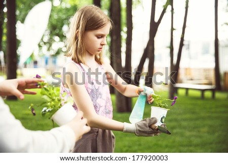 Moscow , Russia - june 1, 2013: Children plant flowers in paper cups and sign your name. Photo made at Moscow on  June 1st , 2013