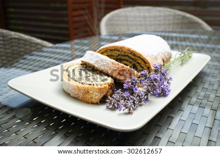 poppy seed roll cake dessert on a plate with lavender flowers in a street coffee