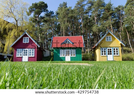 three multi-colored small house, tiny Homes on the lawn in the forest