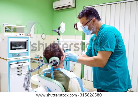Dentist fixes the patient\'s teeth, Mending patient\'s teeth, Photography