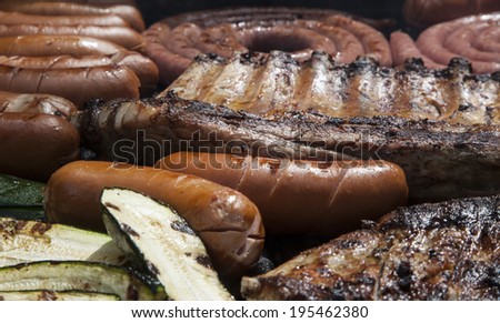 Barbecue with pork ribs, german sausages and courgette