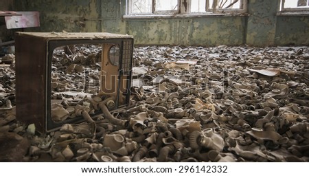 Gas masks on the floor with an old television in an abandoned middle school in Pripyat - Chernobyl nuclear power plant zone of alienation