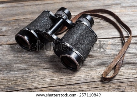 Vintage binoculars on wooden background