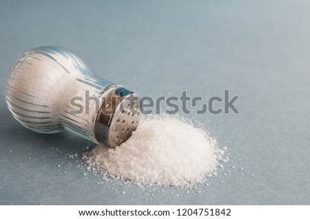 A pile of salt from salt shaker,  concept excessive salt intake