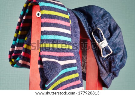 striped colorful Pantyhose with denim cap hang on a  red chair