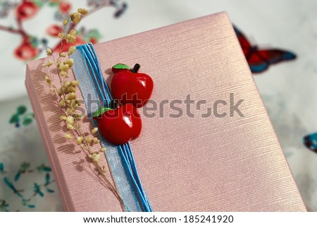 decorated present box  with a red apples and a blue ribbon