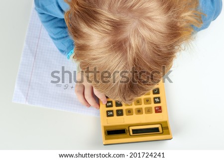 Small child does  calculations with retro calculator