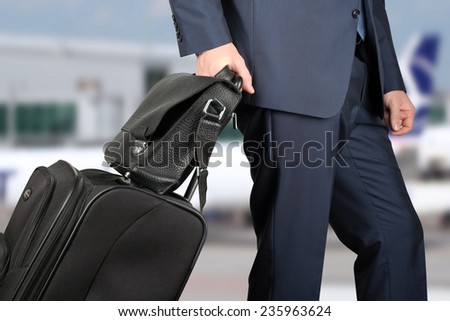 young businessman  in  a modern  stylish suit with  luggage in  the airport
