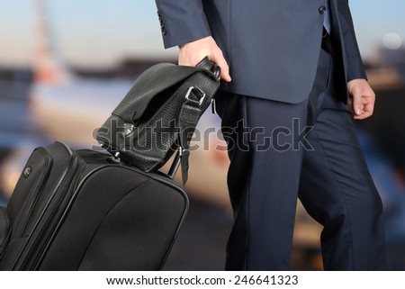 young businessman  in  a modern  stylish suit with  luggage in  the airport