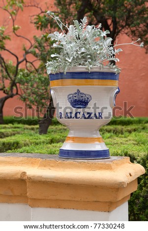 Plant in glazed pot with logo of the famous garden of the Royal Alcazar palace in the center of Sevilla, Andalucia region, southern Spain