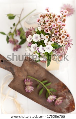 a bunch of flowers and a rusty spade