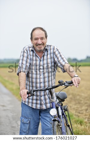 An older man holding handles on a bike.