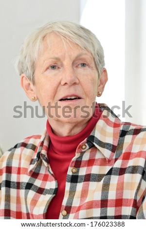 A woman wearing a red jumper and red check shirt.