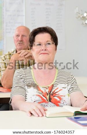 A smiling old woman in front of an old man.