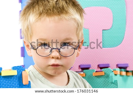 A little boy wearing a pair of wire rimmed glasses.