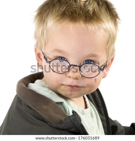 A young boy wearing glasses has a dirty face.