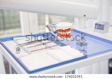 Dental tools and a model of a mouth on a table.