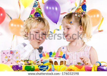 A birthday party with cake, party hats and balloons.