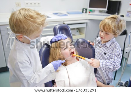 Two boys and a girl pretending to be a dentist, patient and assistant.
