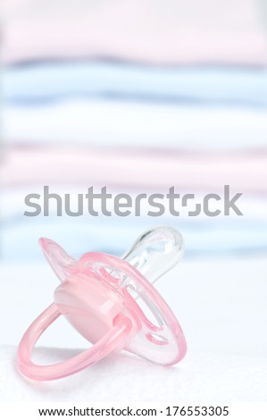 A transparent pink pacifier with a pastel background.