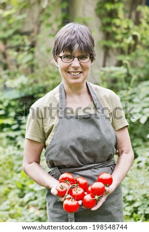 a woman in the garden with fresh tomatoes