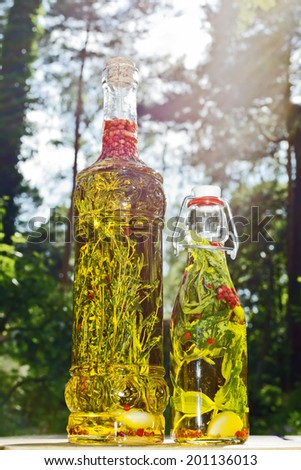 herbs in a bottle with olive oil on a table in the garden