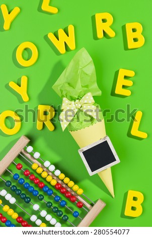 corn shaped present for first day at school with a blackboard tag, abacus and yellow letters on green background