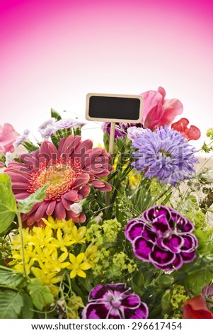 a close up of a bouquet of flowers with a black label (copy space) and a magenta gradient background