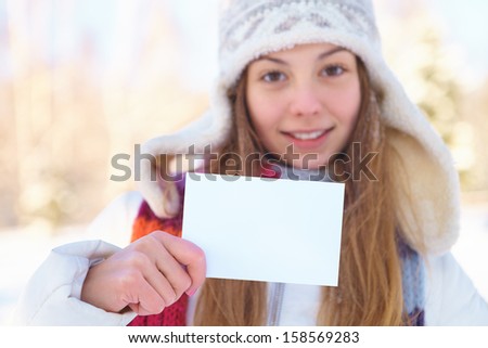 Young beautiful girl with blank banner. Winter.
